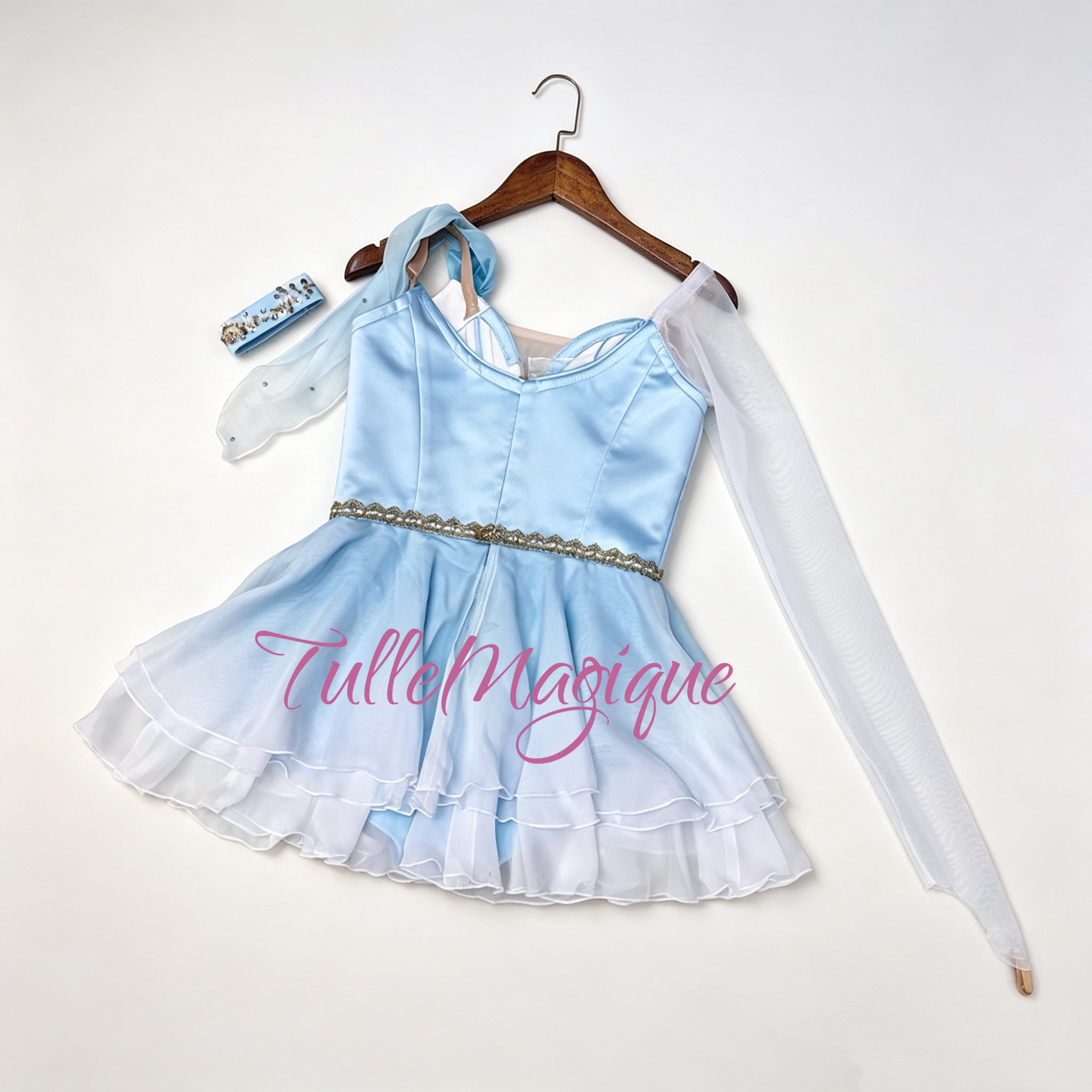 blue Grecian chiton style ballet dress with an asymmetric long white mesh sleeve, detailed with luxury gold lace floral appliqués.⁠
