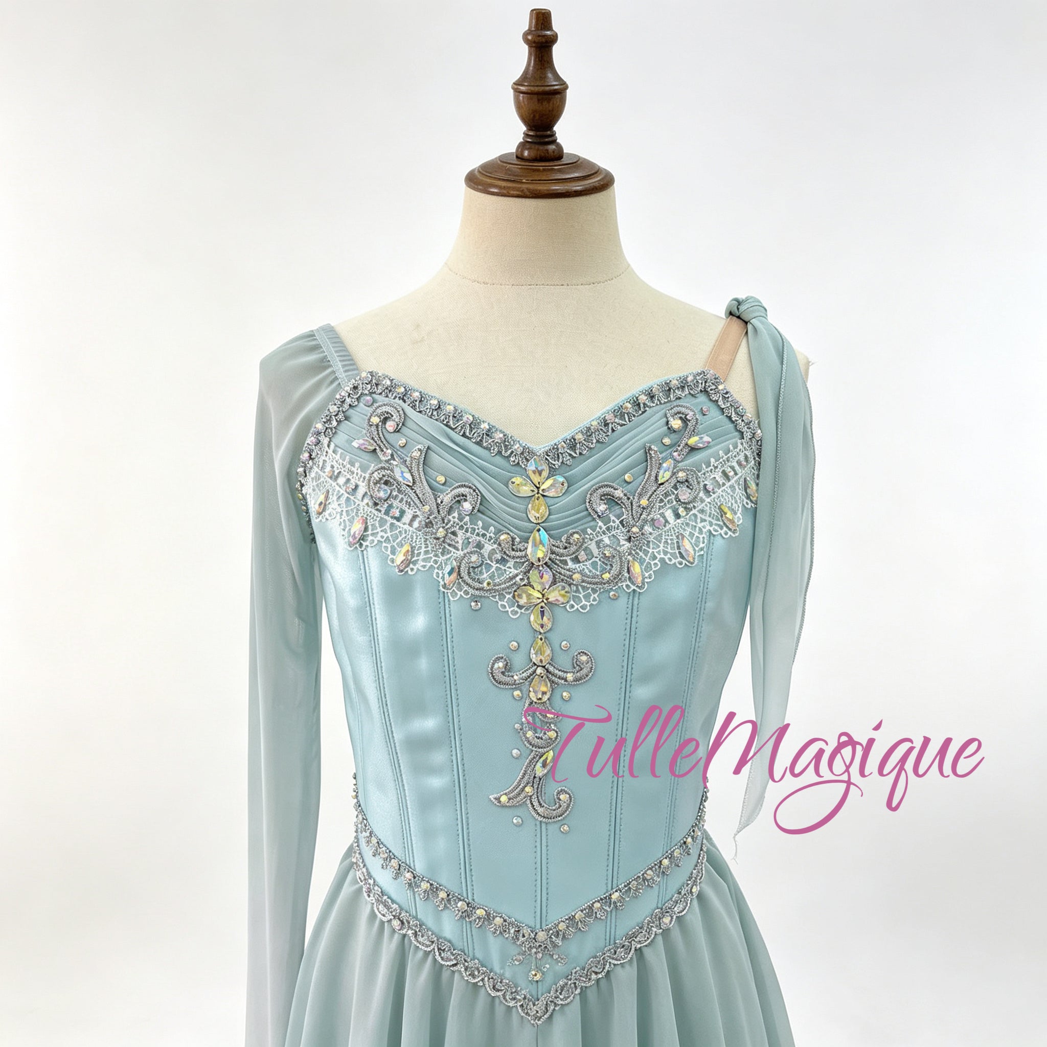 custom-made asymmetric lyrical dance dress or ice skating wear in light gradient blue, highlighting a detailed bodice with central gold and silver crystals and fluid tiered snow chiffon layers