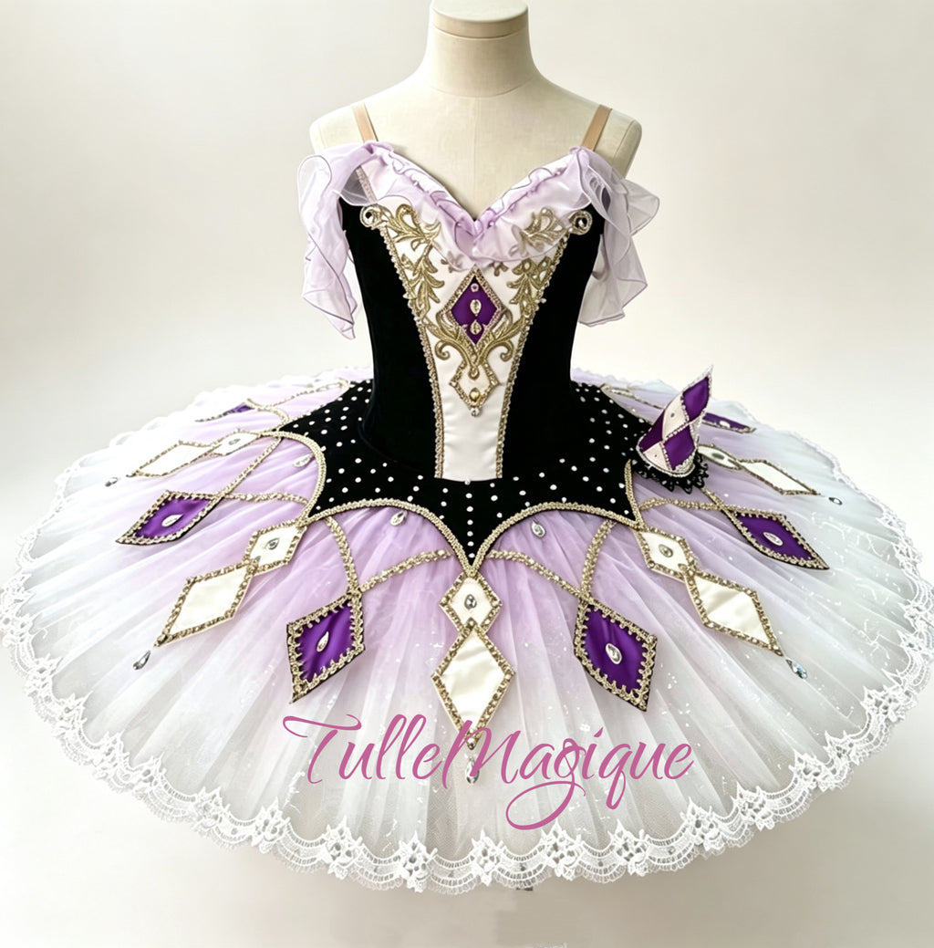 Professional black velvet and purple classical ballet tutu for Satanella or Carnival of Venice variation, featuring a harlequin diamond pattern skirt plate and a mini theatrical hat accessory for YAGP.