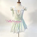 Professional Cupid ballet variation costume, featuring a white to green ombre bodice with symmetrical silver embroidery, a center green crystal, and a bouncy tiered ripple short skirt with rolled hems