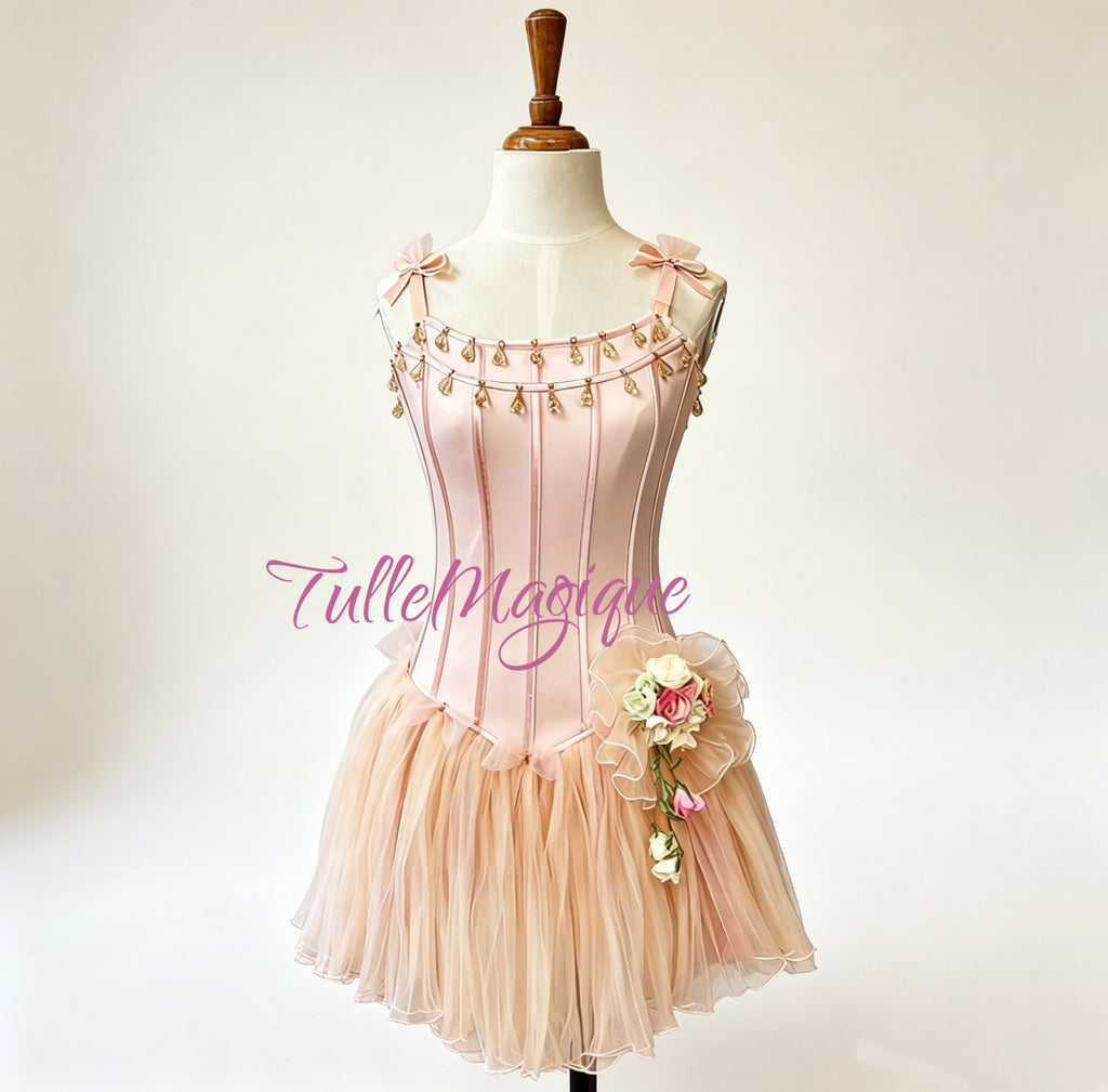 Classical ballet tutu for Dew Drop variation in soft champagne peach, showcasing vertical pink boning lines on the bodice, delicate shoulder ribbon bows, and a multi-layered fluffy mesh skirt