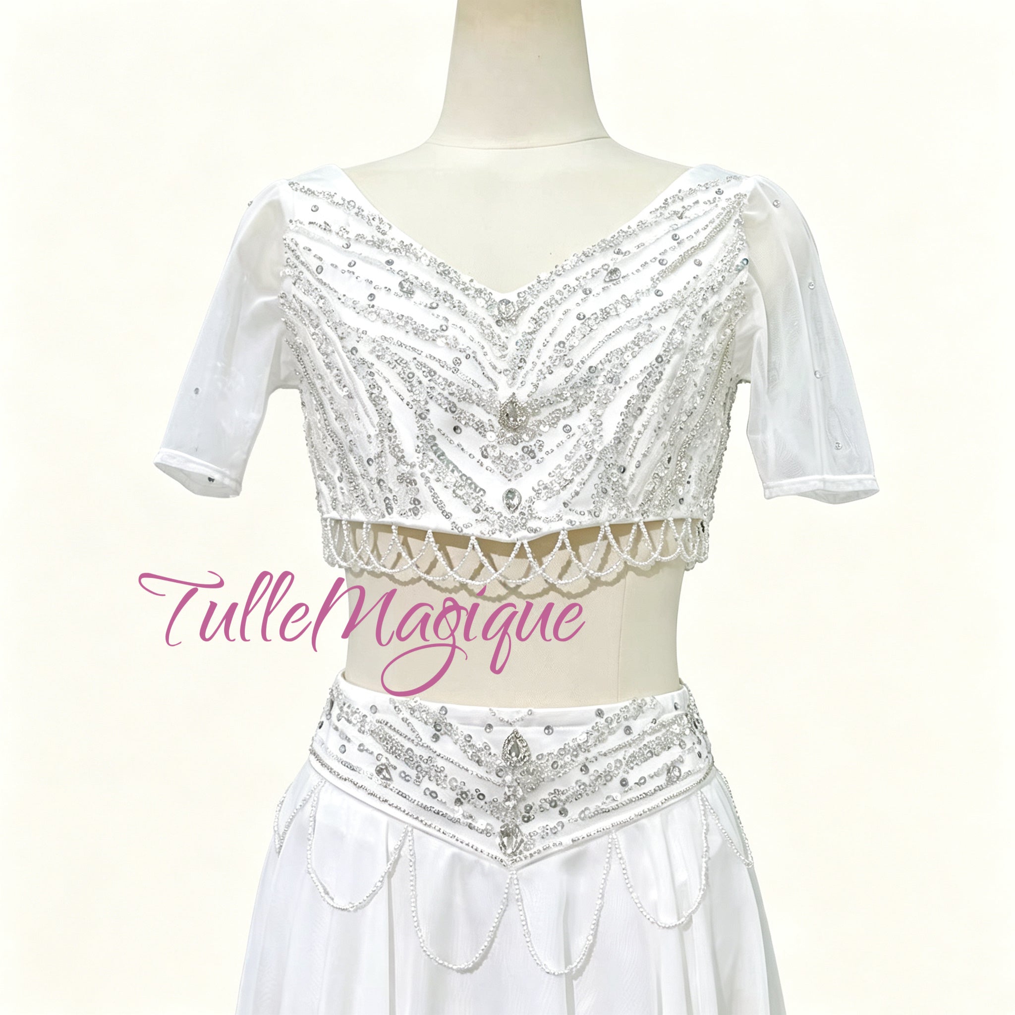 ⁠Close-up of TulleMagique white ballet bodice with luxury silver embroidery, short sleeves, and dangling beaded fringe.⁠