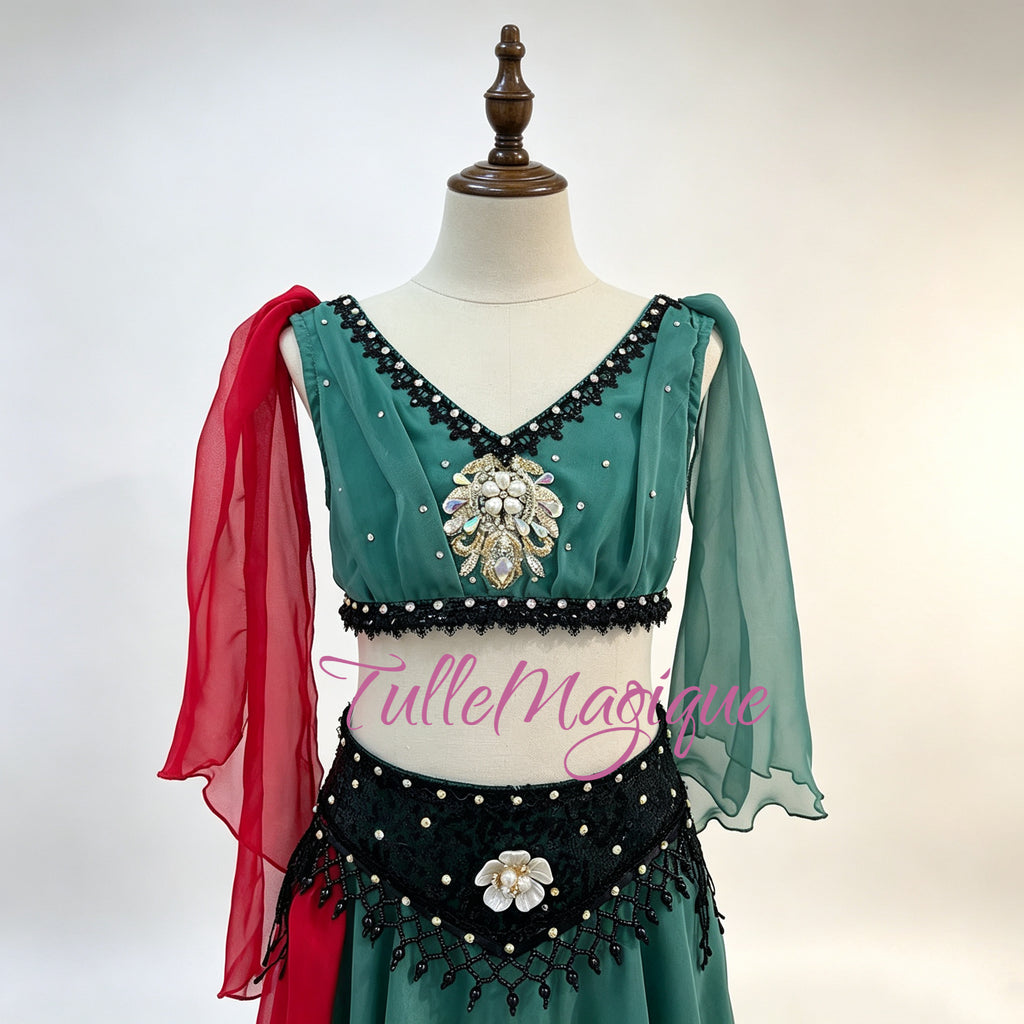 Close-up of floral embroidery and beadwork on a professional green lyrical Le Corsaire ballet costume featuring a lush emerald green palette accented by a contrasting red chiffon drape and delicate black detailing.
