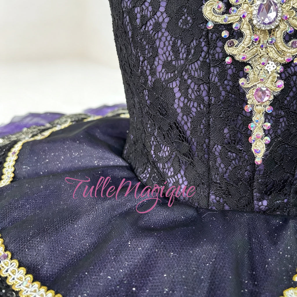 Professional deep purple classical ballet tutu for Raymonda Act 3 variation, featuring a black lace bodice with intricate gold Baroque embroidery and a tiered violet pancake skirt for YAGP.