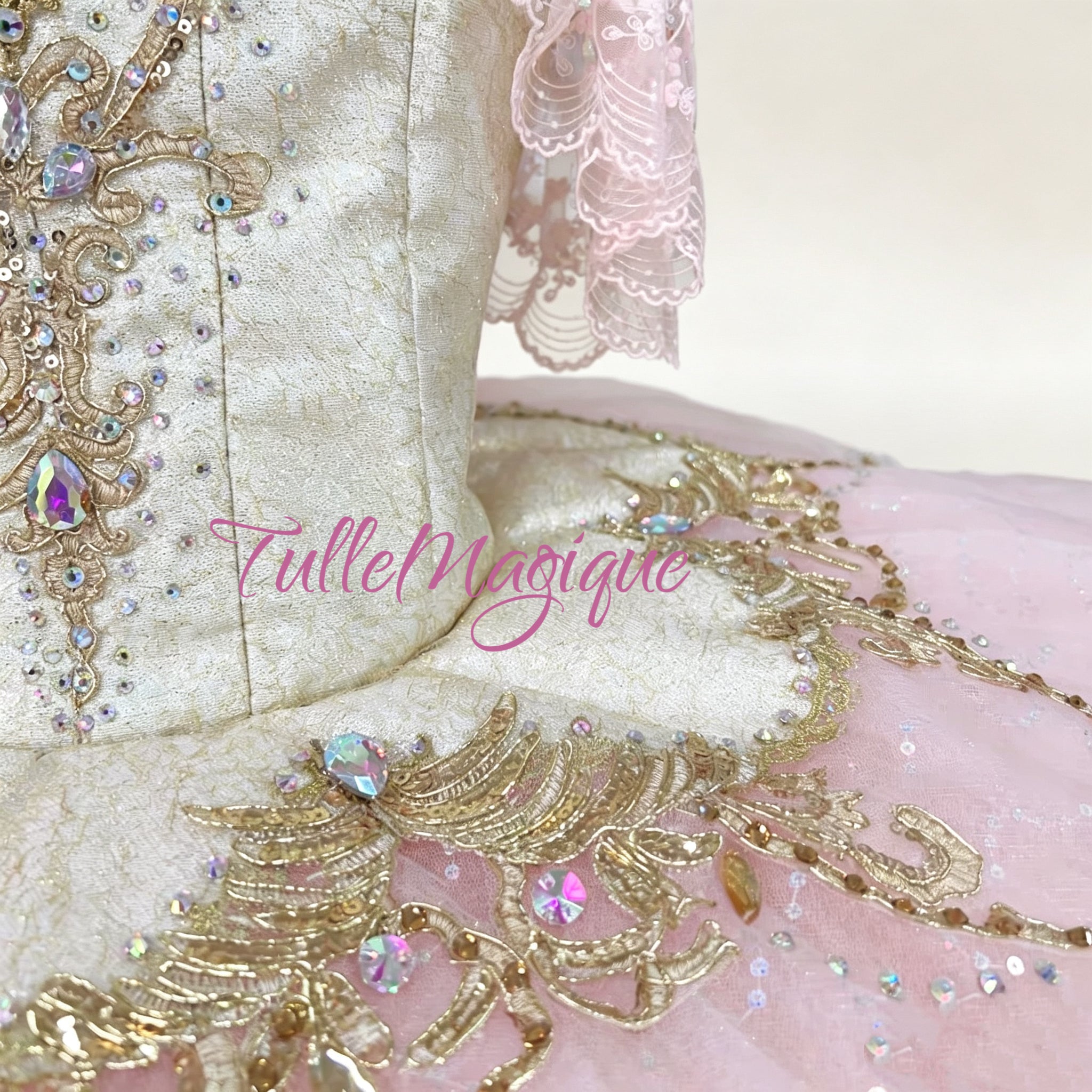 Detailed view of delicate lace sleeves on a professional pink and gold stage tutu for princess Aurora.