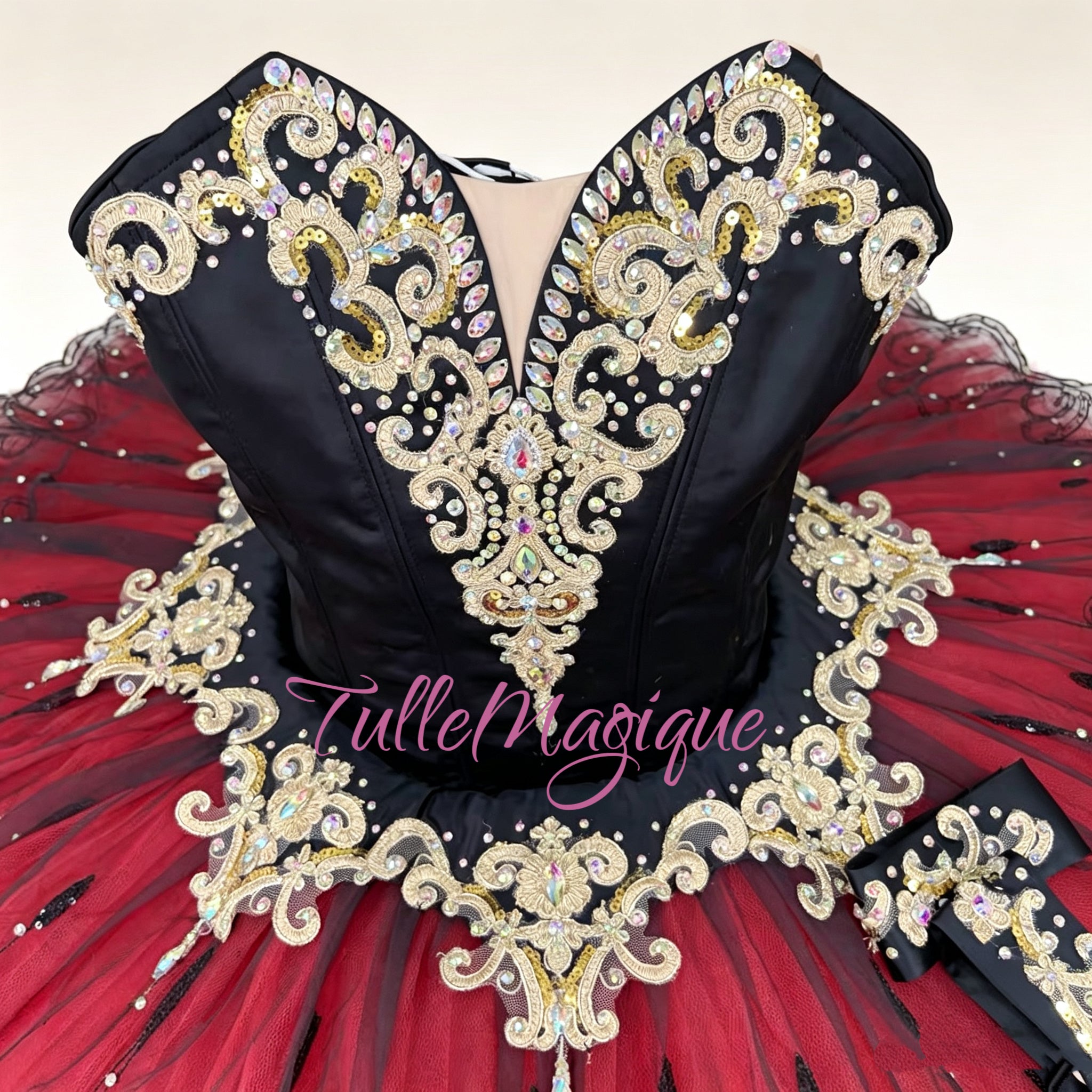 Close-up of intricate gold embroidery and crystals on a professional black ballet bodice.