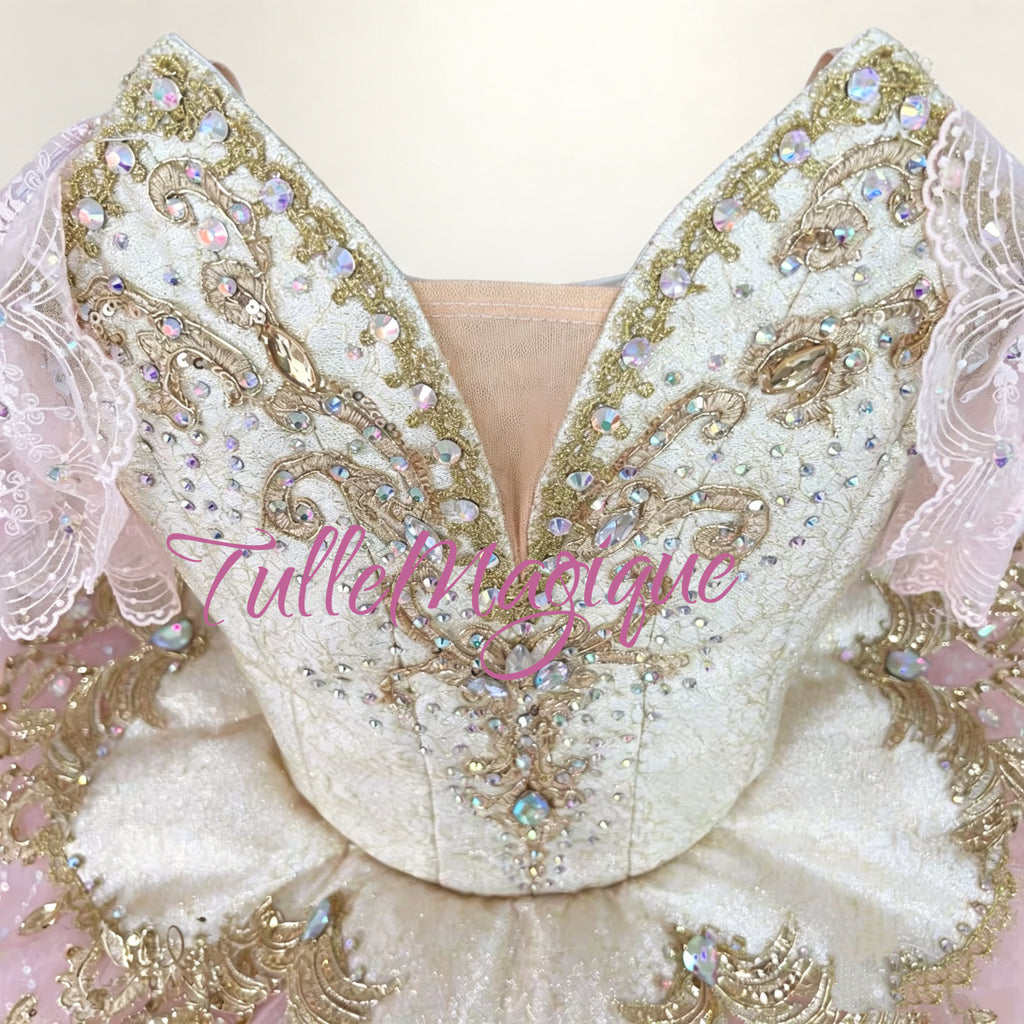 Close-up of intricate gold embroidery and crystals on a professional pink ballet bodice for sleeping beauty & the nutcracker.