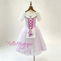 Front view of a professional lavender romantic ballet tutu featuring a lilac bodice with magenta criss-cross ribbons, an embroidered floral apron, and a lace-trimmed tulle skirt.