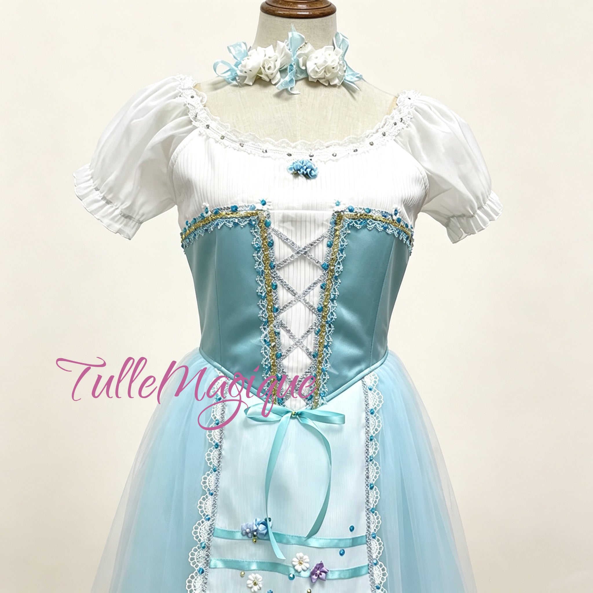 professional ballet giselle romantic tutu wiht light blue satin ballet bodice showcasing silver criss-cross corset lacing, delicate white pleated chiffon, and intricate gold and silver lace trims