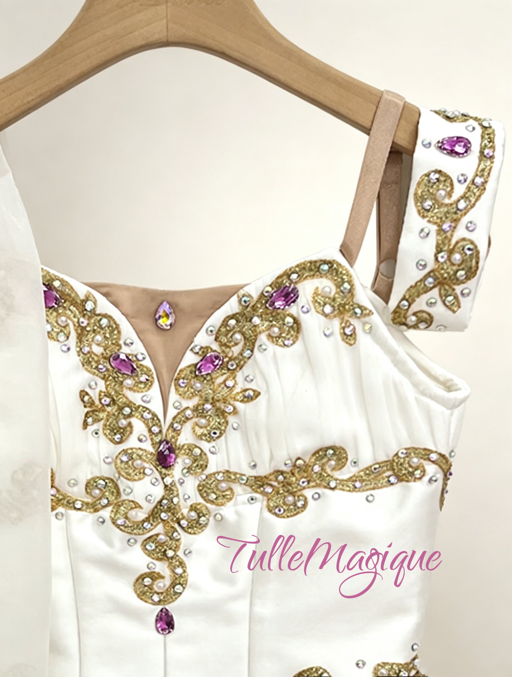 A luxury Grecian style chiton ballet costume showcasing a detailed white bodice with royal gold scrollwork, fuchsia crystals, and a flowing chiffon short skirt. 