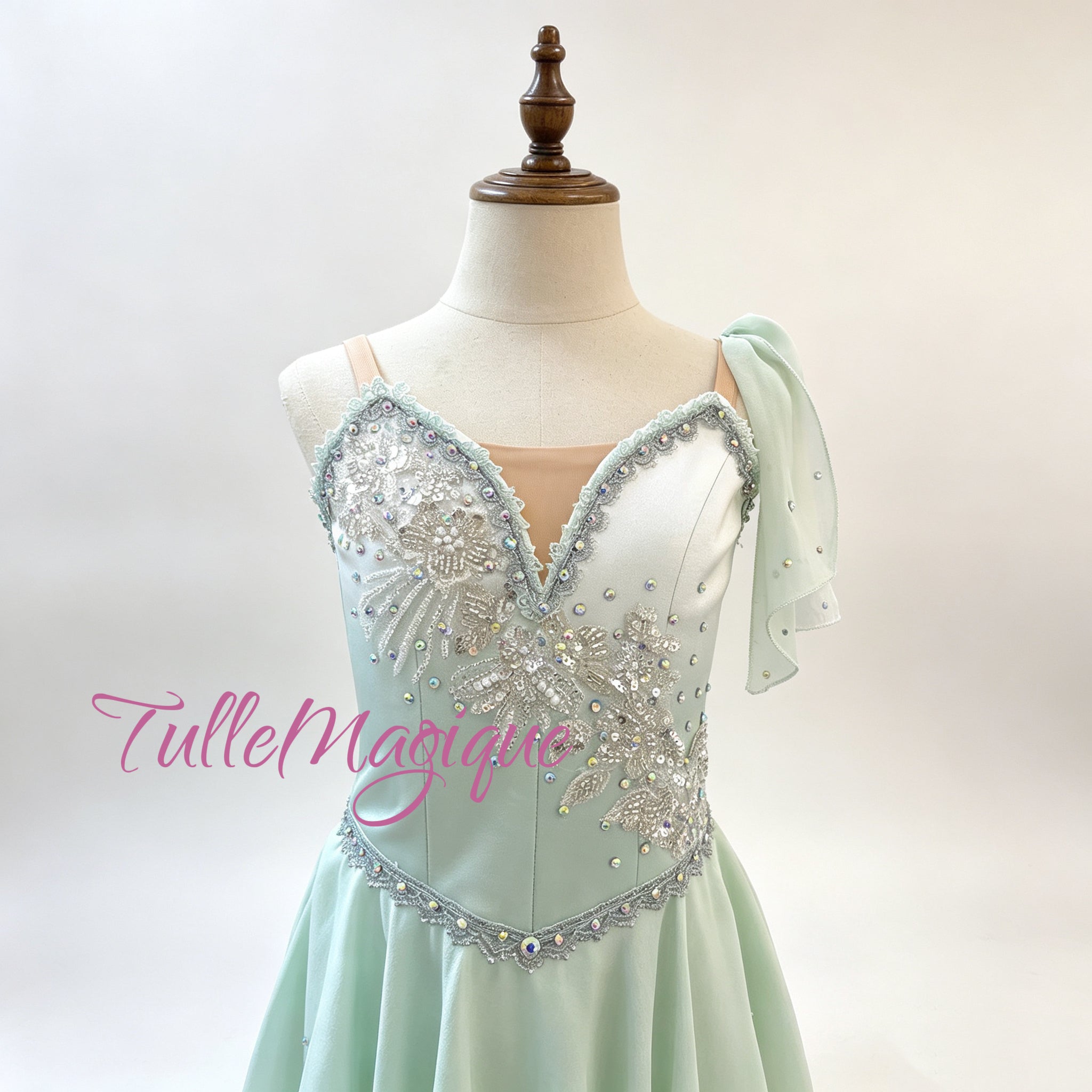 Greek style mint green ballet tunic for Talisman variation, showcasing a detailed bodice with sparkling silver rhinestone trim and a signature shoulder drape on a mannequin
