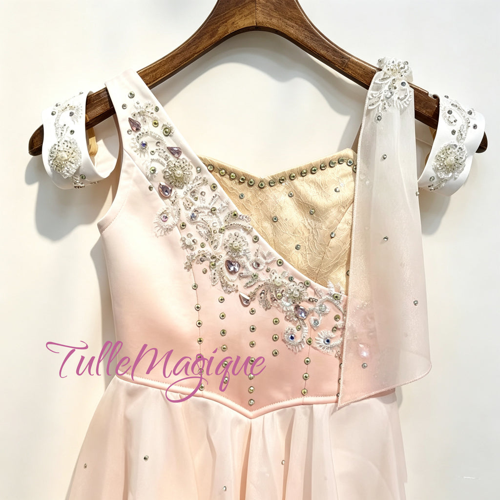 Greek style ballet lyrical tutu for Talisman variation, showcasing a peach pink to white ombre chiffon skirt, a single shoulder drape, matching detatchable arm bands, and delicate rhinestone accents. Professional custom made per measurements for ballet stage wear.