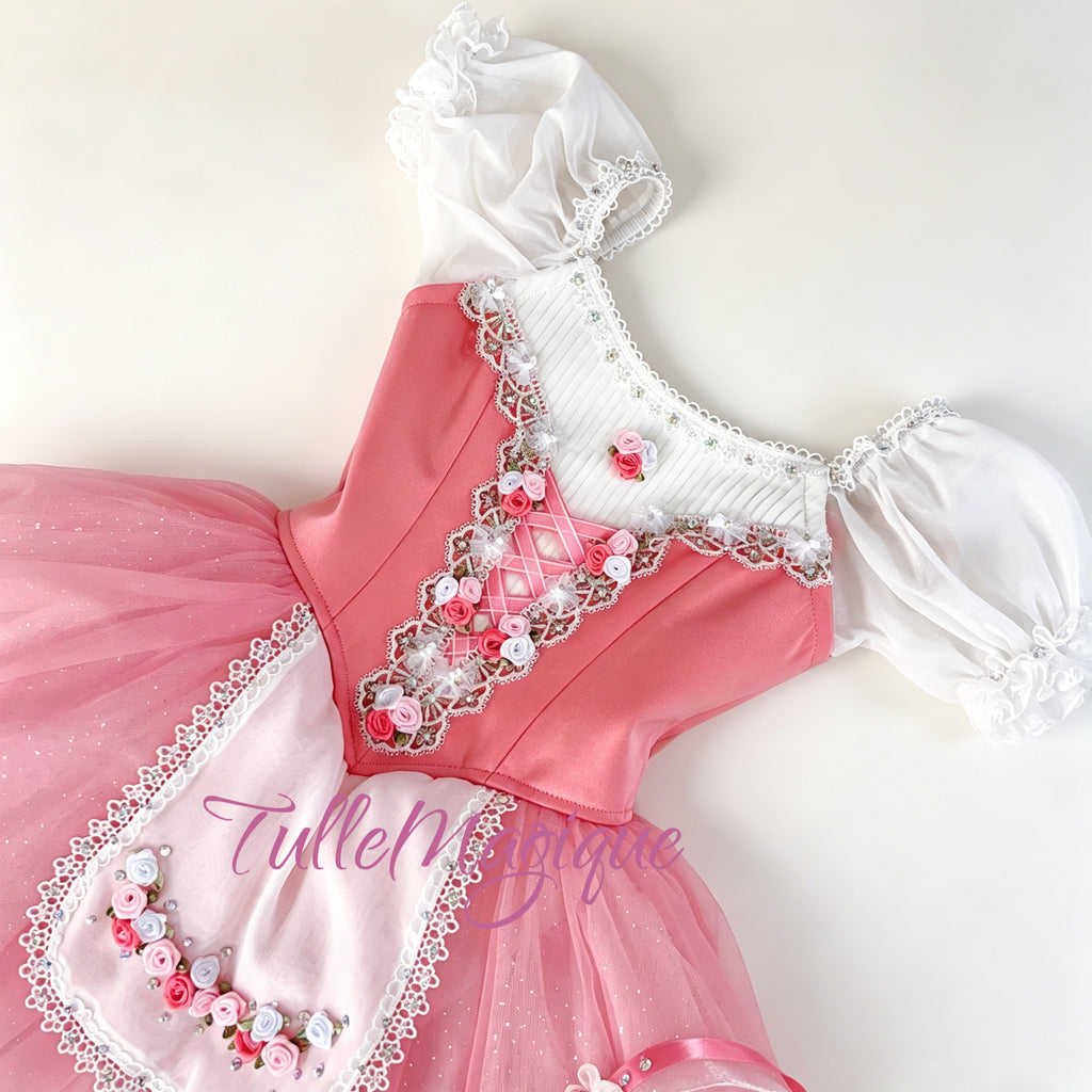 Close-up of the front bodice from the ballet costume showcasing the deep pink satin fabric, white pleated chiffon neckline, criss-cross ribbon lacing, and 3D ribbon rose embroidery with rhinestones. Apron with  beautiful 3D flowers.