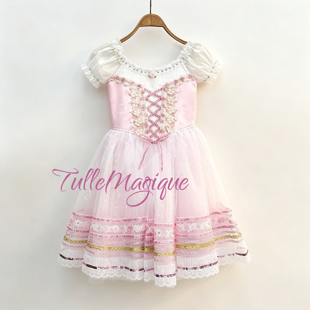 Professional pink romantic ballet tutu featuring a rose pink bodice with ribbon lacing, puff sleeves, and a layered tulle skirt decorated with pink satin and gold sequin ribbons