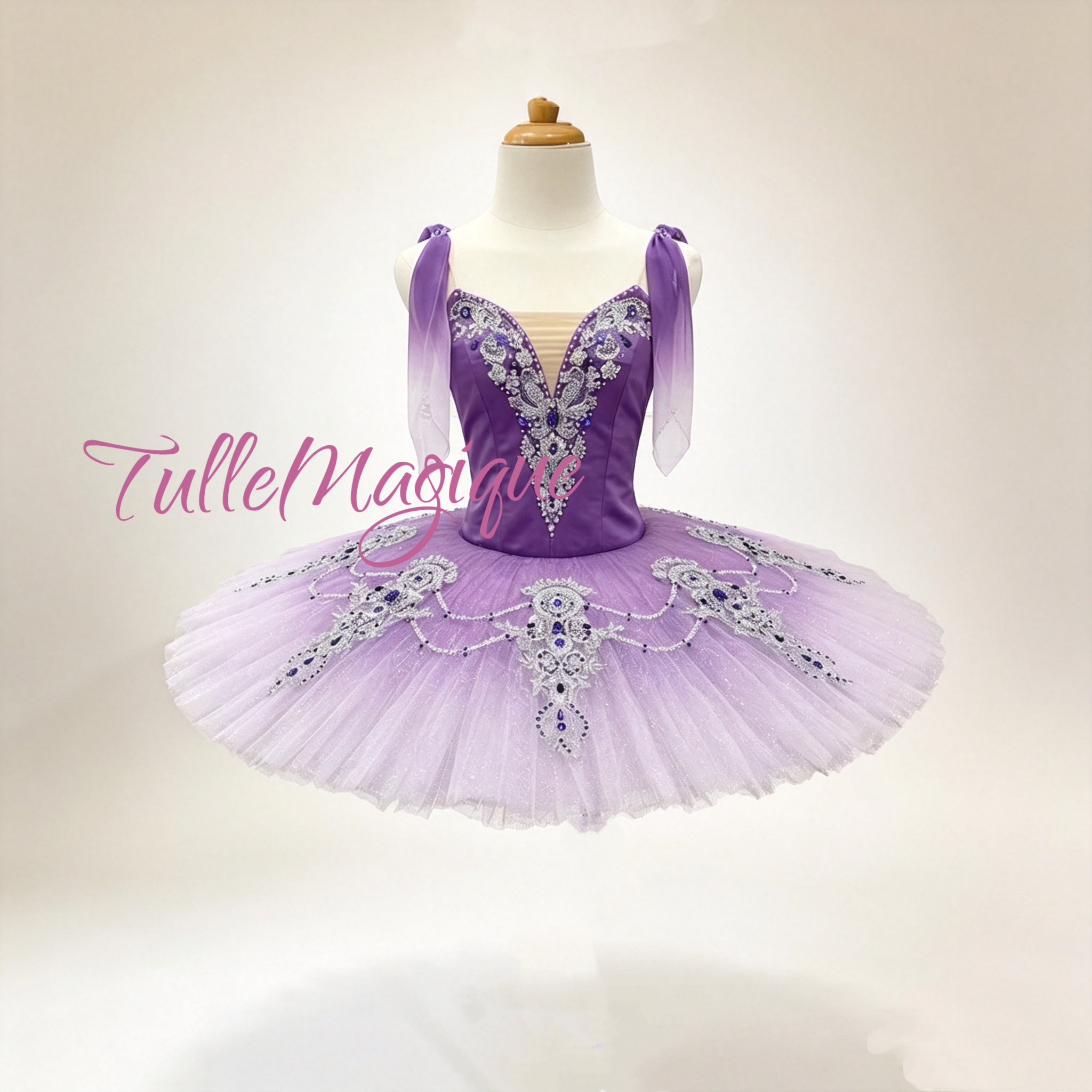 A purple and lavender ballet tutu costume featureing a purple bodice with silver rhinestone embellishments, sheer lavender shoulder straps, and a voluminous lavender tulle skirt with matching rhinestone details.