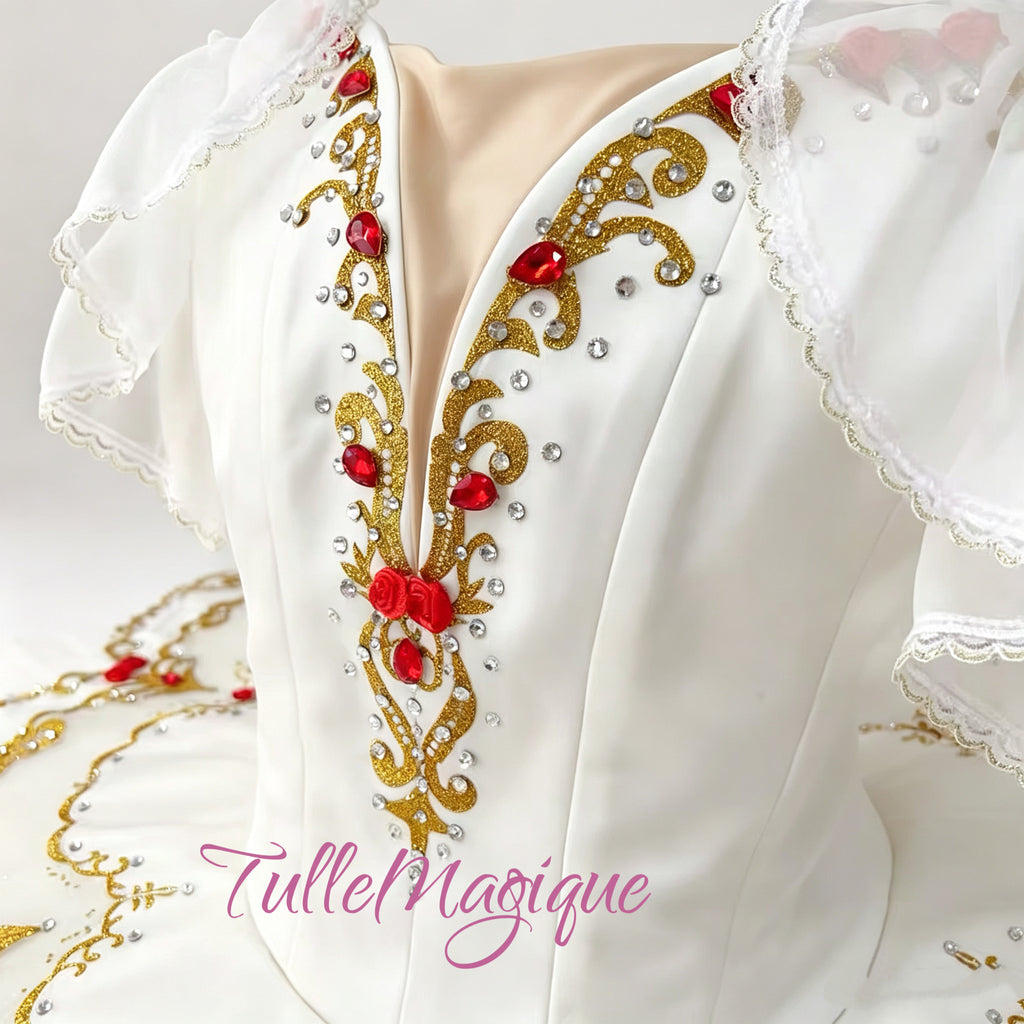 white classical tutu with intricate gold scrollwork and red gemstone accents.