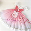 Flat lay full view of a professional rose pink and white peasant ballet costume featuring a pink satin bodice with ribbon lacing, an embroidered rose apron, and a matching floral headpiece.