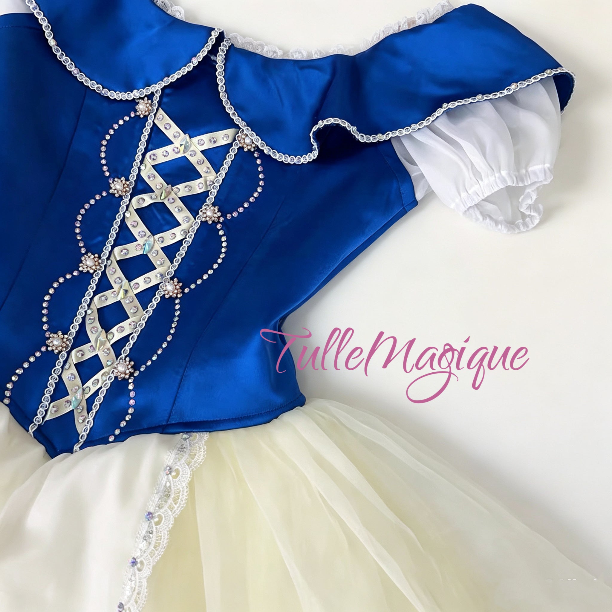 Close-up of the royal blue ballet romantic tutu bodice showcasing white criss-cross corset lacing, double rhinestone chain trim, and a specail blue uffled collar