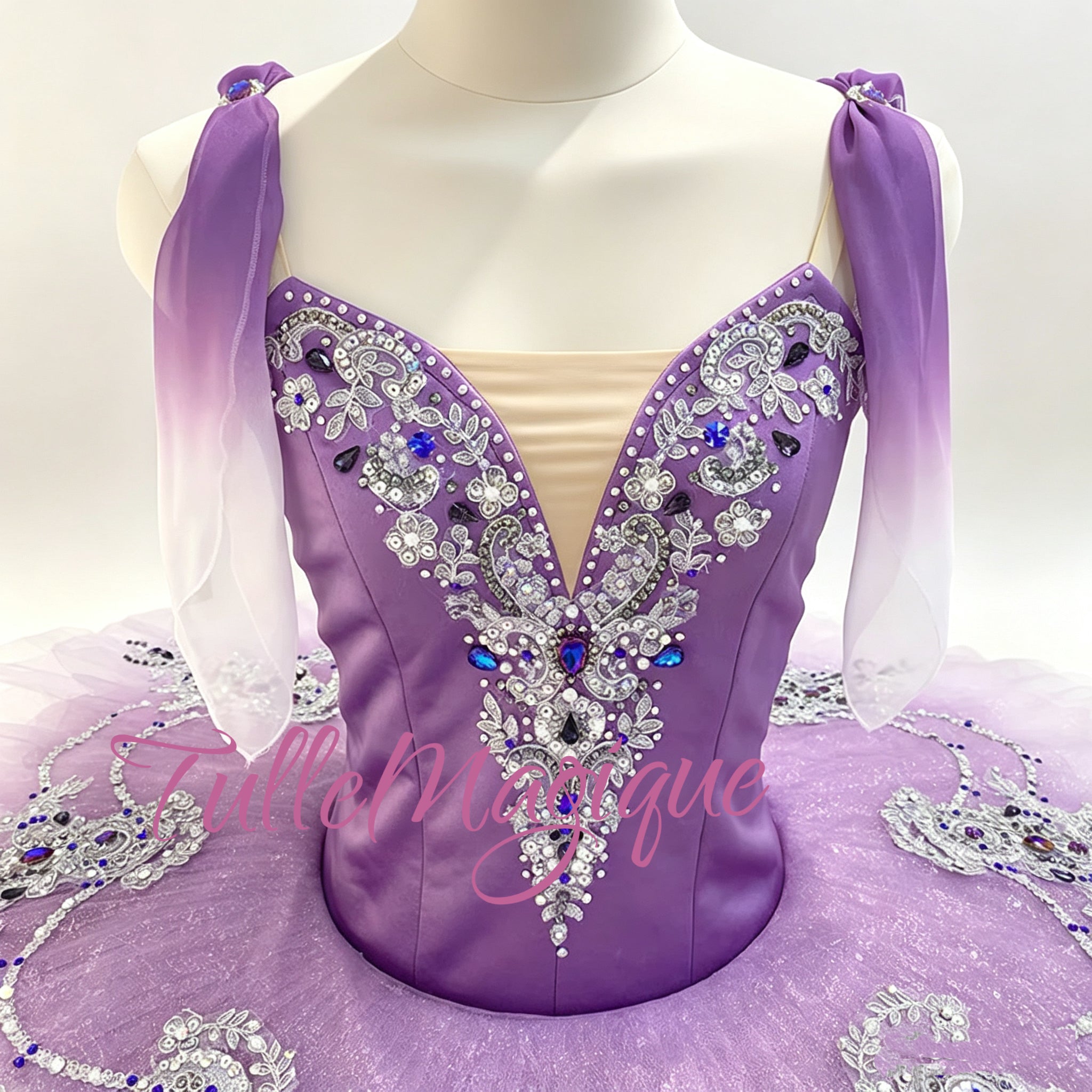 Close-up of intricate silver embroidery and jewels on a professional purple ballet bodice. With purple gradient shoulder drap.