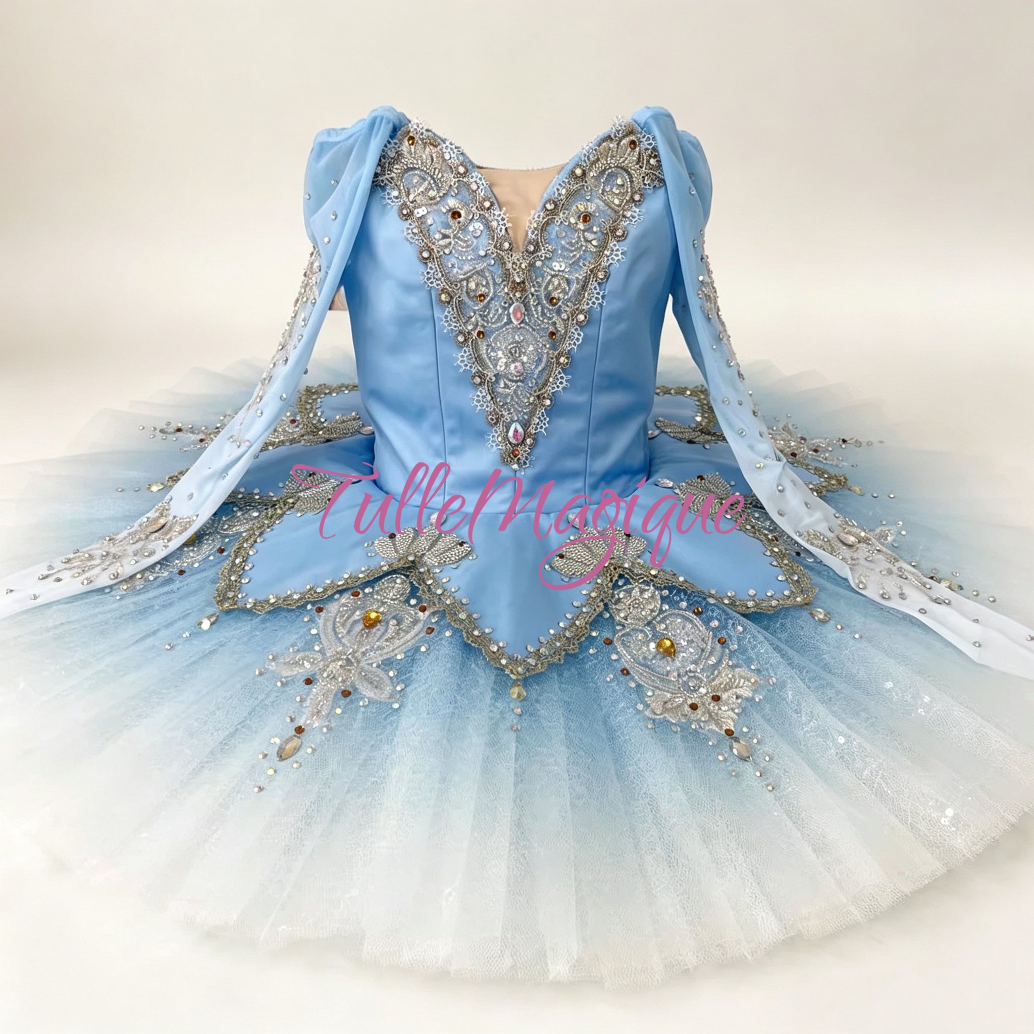 A light blue ballet tutu dress with silver and white beaded embellishments, featuring a V-neck bodice, long sheer sleeves. Professional classical ballet tutu for Snow Queen and Bluebird variations.