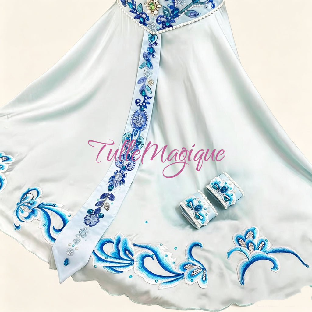 ⁠Close-up of a professional ballet crop top with ornate leaf embroidery, pearls, blue rhinestones, and a hanging beaded fringe⁠