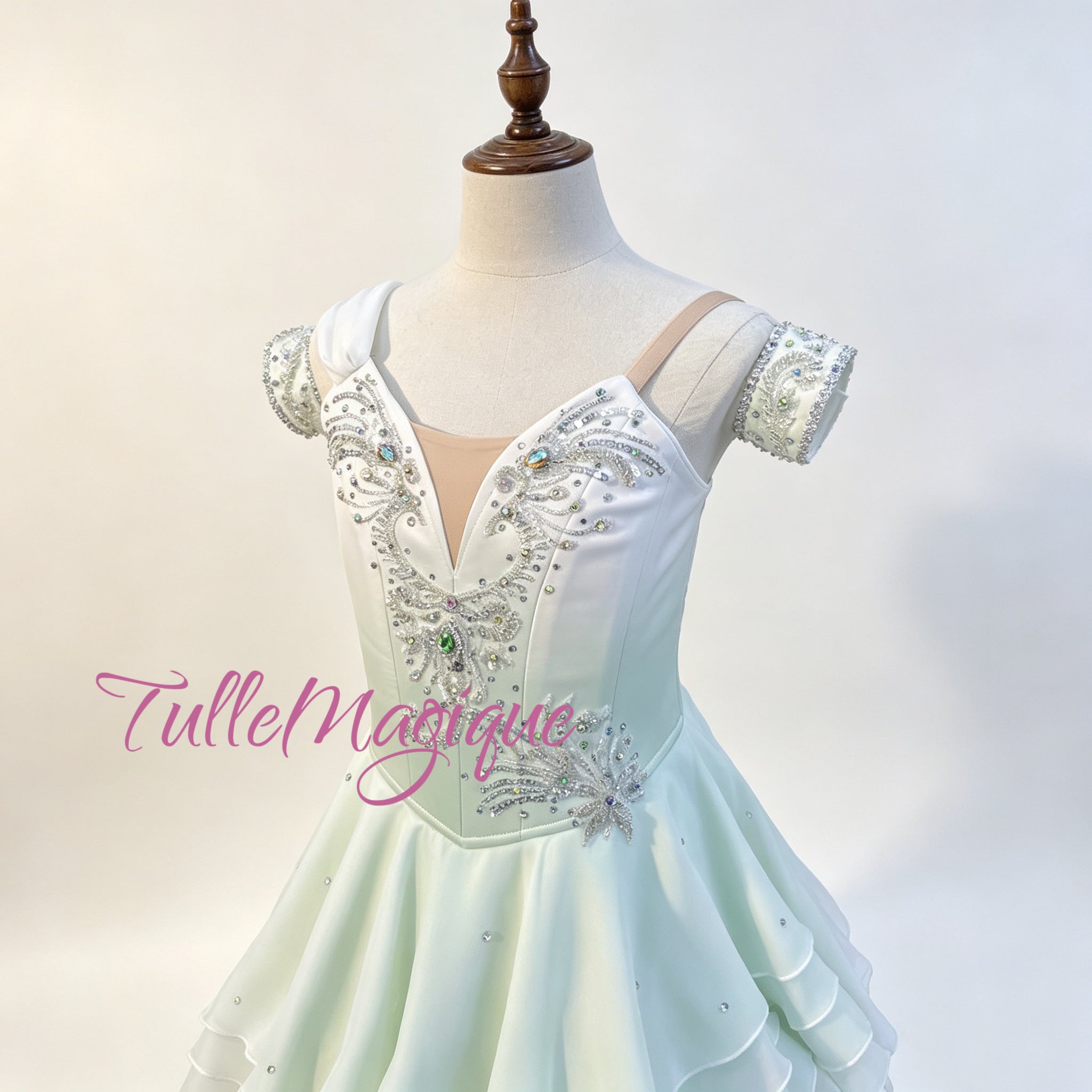 High-quality Water Spring ballet variation dress, highlighting a unique tiered wave-like short skirt with lettuce edges, double off-the-shoulder arm bands, and a sparkling central green gemstone
